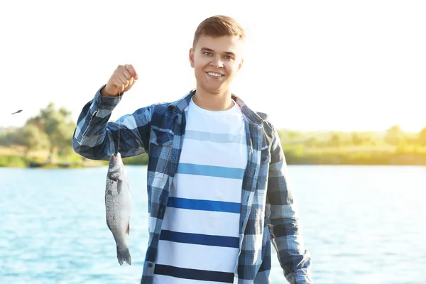 갓을 들고 젊은 남자는 강 근처에 물고기를 잡 았 — 스톡 사진