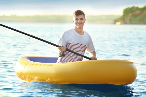 Junger Mann fischt von Schlauchboot auf Fluss — Stockfoto