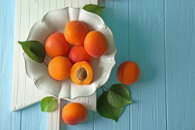 Ahşap masa üzerinde taze kayısı ile plaka