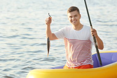 Nehri üzerinde şişme tekneden balıkçılık genç adam