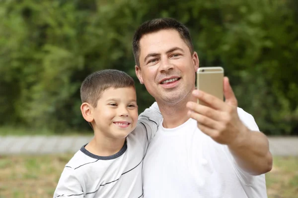 Padre e figlio si fanno selfie nel parco — Foto Stock