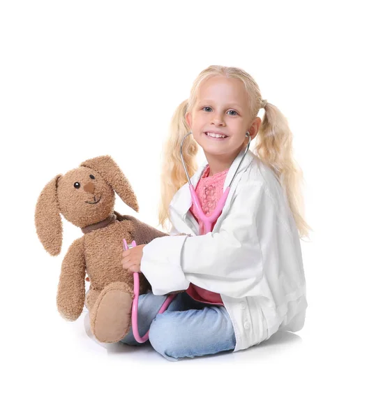 Маленькая девочка сидит в медицинском пальто с кроликом изолированы на белом — стоковое фото
