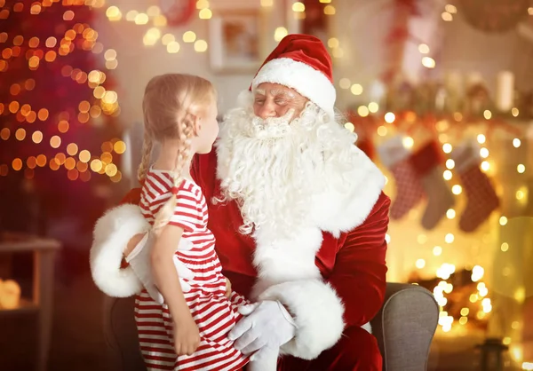 可爱的小女孩坐在圣诞老人的大腿上, 房间里有美丽的圣诞装饰品 — 图库照片