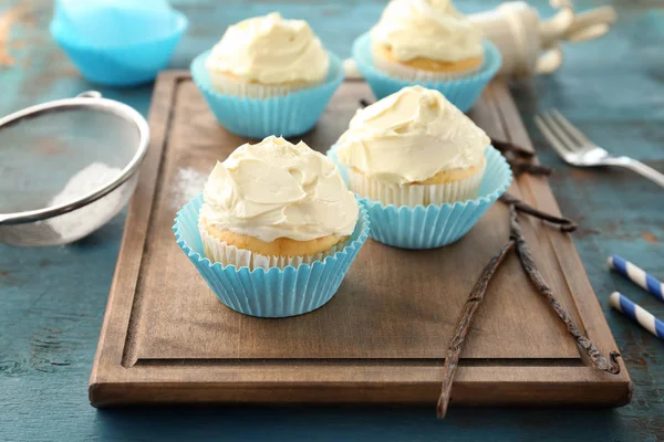 Cupcakes de baunilha saborosos na placa de madeira — Fotografia de Stock