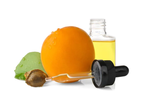 Botella de aceite de albaricoque con fruta fresca sobre fondo blanco —  Fotos de Stock