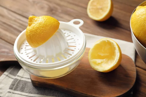 Сжиматель для лимона на деревянном столе — стоковое фото