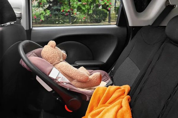 Asiento de seguridad para niños con adorable osito de peluche en coche — Foto de Stock