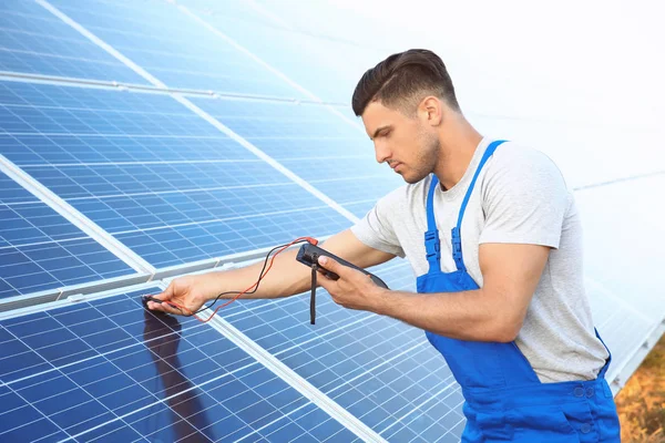 Trabajador que comprueba paneles solares — Foto de Stock