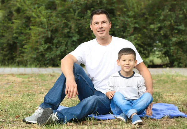 Glücklicher Vater und Sohn ruhen sich im Park aus — Stockfoto
