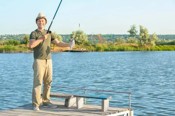 Hombre pescando desde el muelle en el río — Foto de Stock