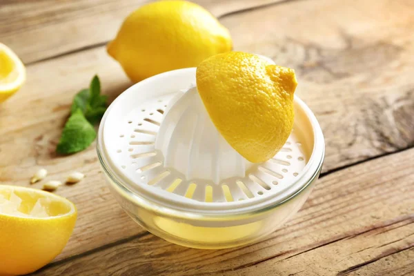 Exprimidor de limón sobre fondo de madera —  Fotos de Stock