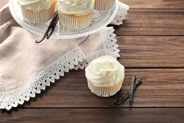 Tasty vanilla cupcake on wooden table — Stock Photo, Image