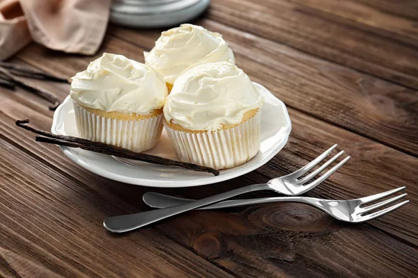 Tasty vanilla cupcakes on plate — Stock Photo, Image