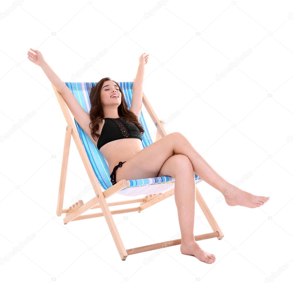  young woman sitting on deck chair 
