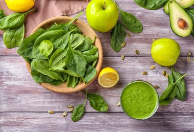 Ahşap arka plan üzerinde ıspanak güler yüzlü ile kompozisyon