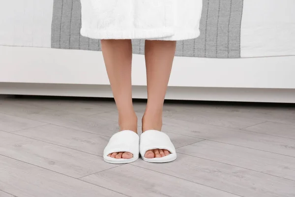 Mujer de pie en zapatillas de spa blancas en parquet gris — Foto de Stock