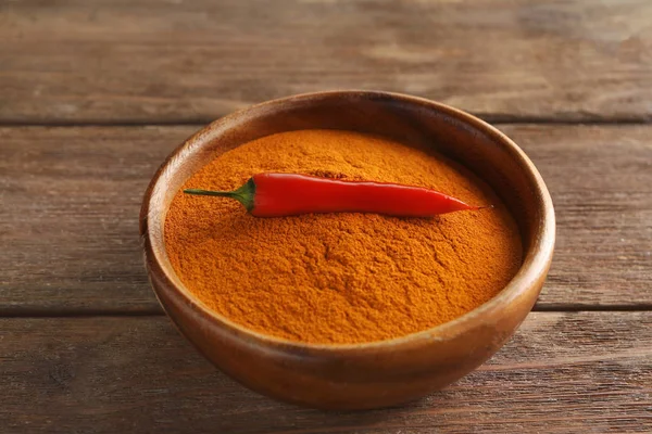 Chili powder and raw pepper in bowl — Stock Photo, Image
