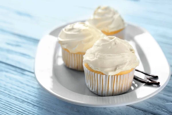 Tasty vanilla cupcakes on plate — Stock Photo, Image