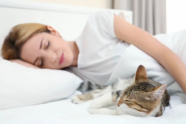 Şirin kedi ve genç kadın yatakta rahatlatıcı — Stok fotoğraf