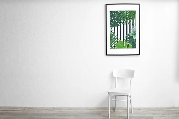 Картинка тропических листьев и деревянного кресла на фоне белой стены — стоковое фото