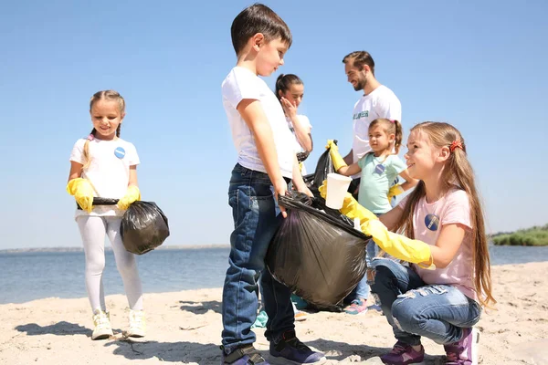若いボランティアや子供のビーチでゴミを収集 — ストック写真