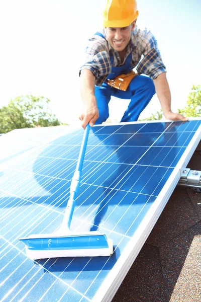 Worker cleaning solar panels Stock Photo