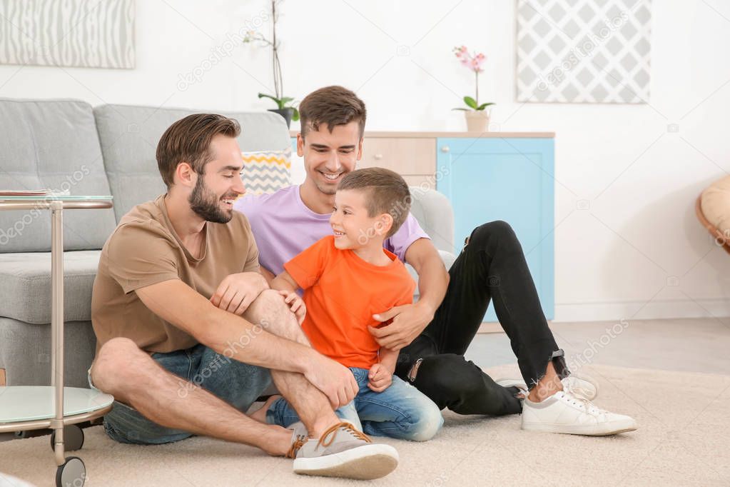 Homosexual male couple with foster son at home. Adoption concept