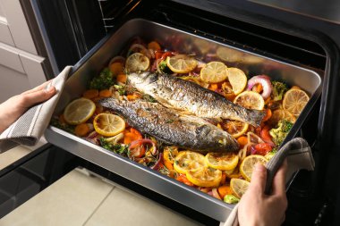 Balık Fırın tepsisini alarak kadın 