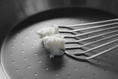 Hindistan cevizi yağı tava üzerinde erime ile metal spatula