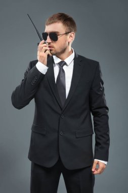 Yakışıklı güvenlik görevlisi gri arka plan üzerinde