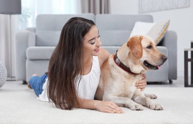 Genç kadın sarı av köpeği ile evde istirahat