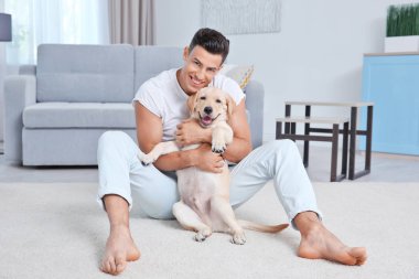 Genç adam sarı av köpeği ile evde istirahat