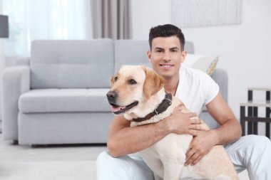 Genç adam sarı av köpeği ile evde istirahat