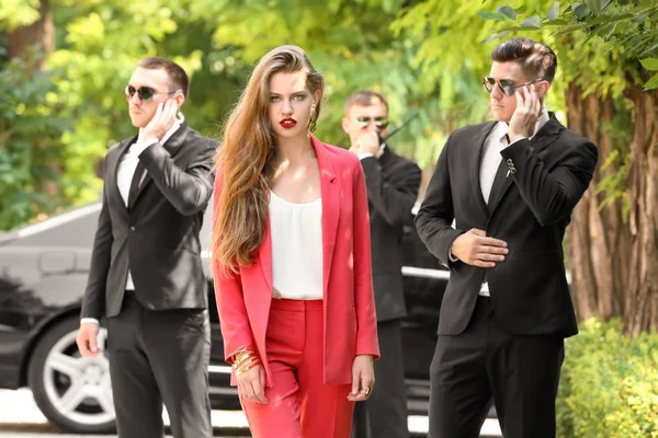 Young businesswoman with bodyguards — Stock Photo, Image