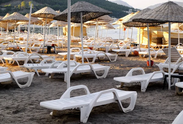 Comfortable sun loungers on sea beach at resort — Stock Photo, Image