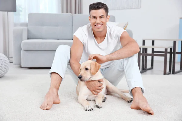 Joven descansando con amarillo retriever en casa — Foto de Stock