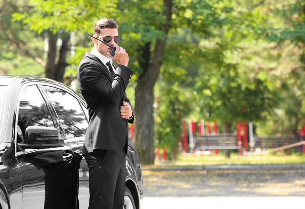 Knappe bodyguard in de buurt van de auto buiten — Stockfoto