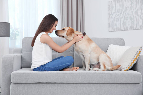 Young woman resting with yellow retriever at home