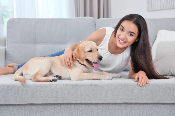 Genç kadın sarı av köpeği ile evde istirahat — Stok fotoğraf