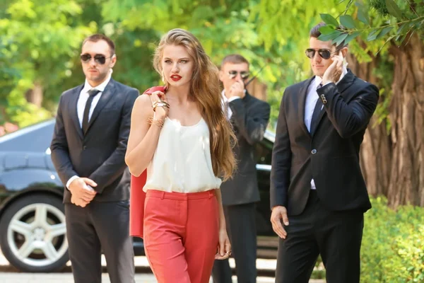 Jeune femme d'affaires avec gardes du corps — Photo