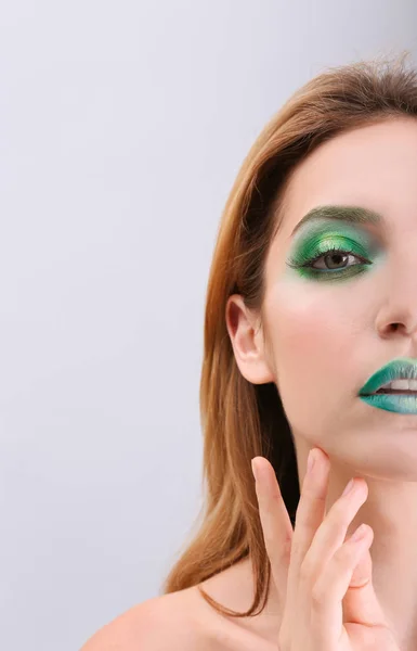 Ung kvinna med ljus grön makeup — Stockfoto