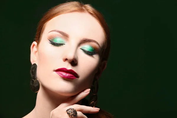 Mulher ruiva bonita com maquiagem verde brilhante no fundo escuro — Fotografia de Stock