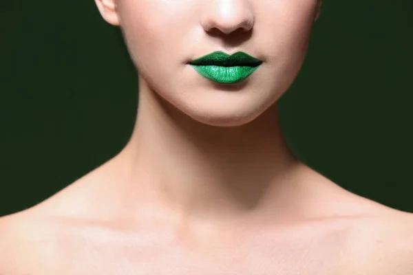 Молодая женщина с творческим макияжем на цветном фоне — стоковое фото