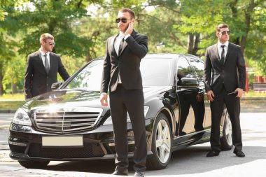 Handsome bodyguards near car   clipart