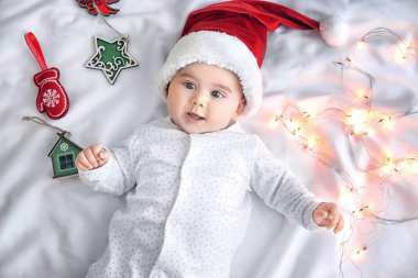 Şirin Bebek Noel ışıkları ve süslemeleri beyaz sayfa üzerinde Santa şapkalı