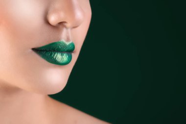 Koyu arka plan üzerinde yaratıcı makyaj ile genç kadın