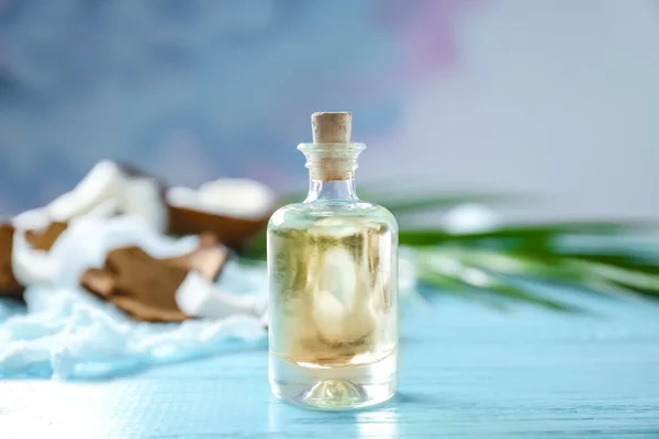 Бутылка с кокосовым маслом на деревянном столе — стоковое фото
