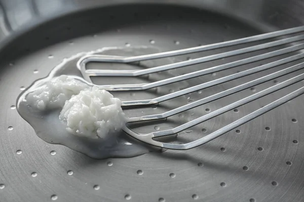 Metallspachtel mit schmelzendem Kokosöl auf Pfanne — Stockfoto