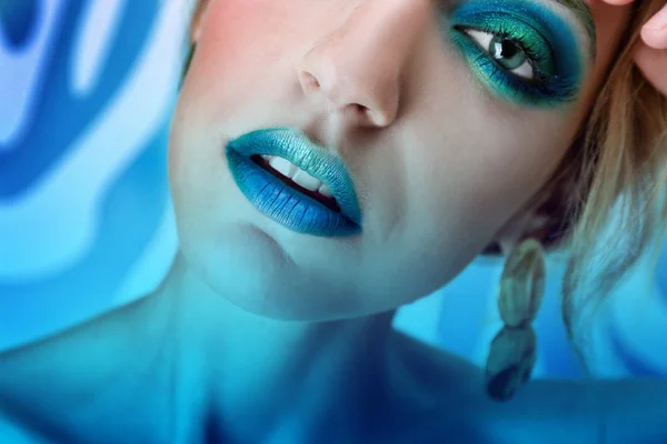 Jeune femme avec un maquillage lumineux sur fond de couleur, gros plan — Photo