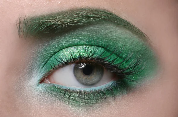 Jeune femme avec un maquillage vert vif, gros plan — Photo